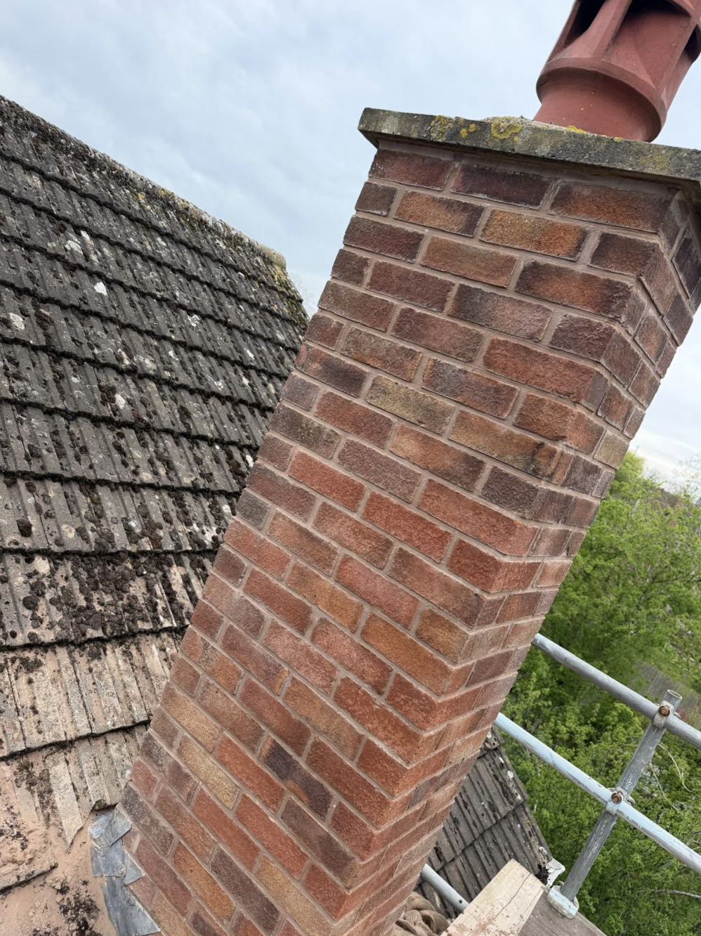Rebuilt brick chimney stack with terracotta cowl